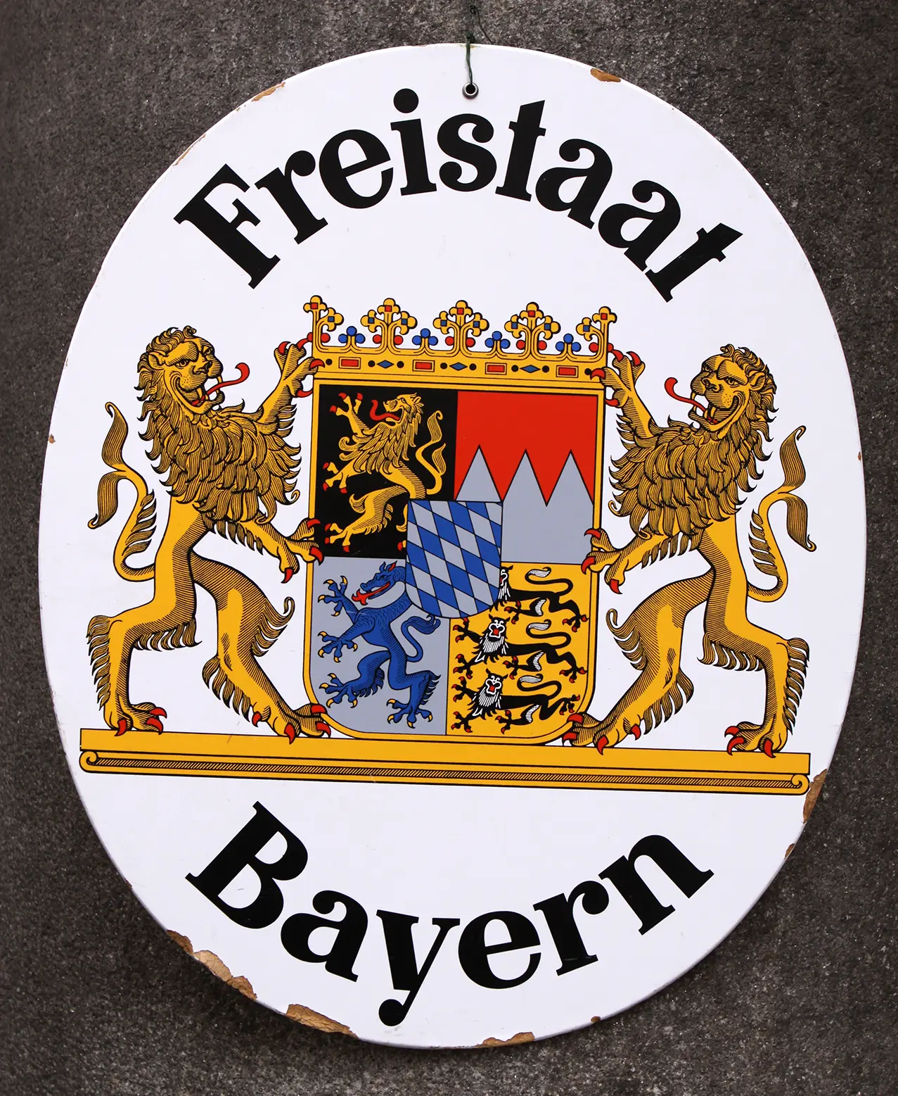 A hanging sign displays the elaborately designed coat of arms of Bavaria.